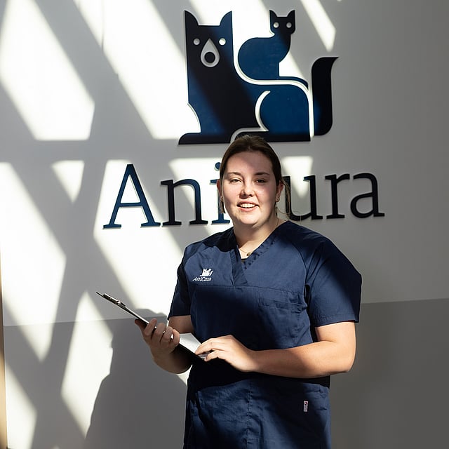 Una persona in camice blu che tiene un blocco per appunti.