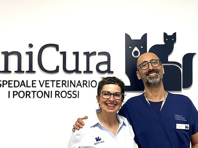 Una persona e una persona in piedi davanti a un cartello.
