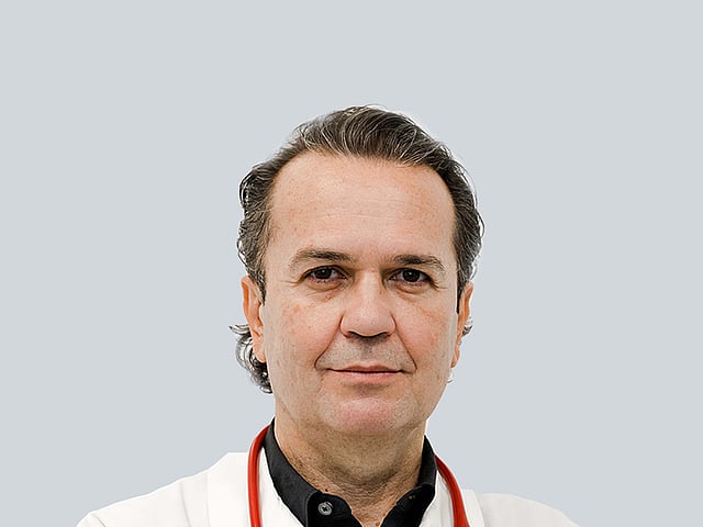 Una persona che indossa un camice bianco con uno stetoscopio rosso al collo.